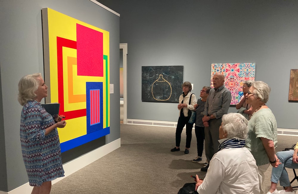 Cedars of Chapel Hill members listening to a guide at Ackland Art Museum, experiencing a tour of diverse art collections.